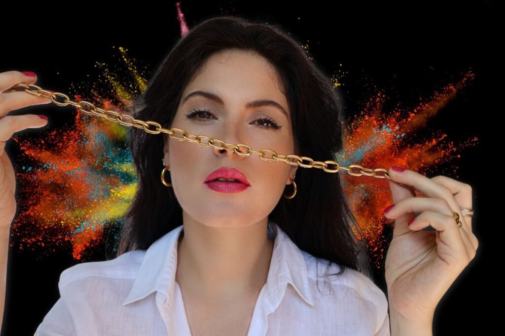 Portrait of Valentina Leardi showing a gold chain and an explosion of colors in the background.