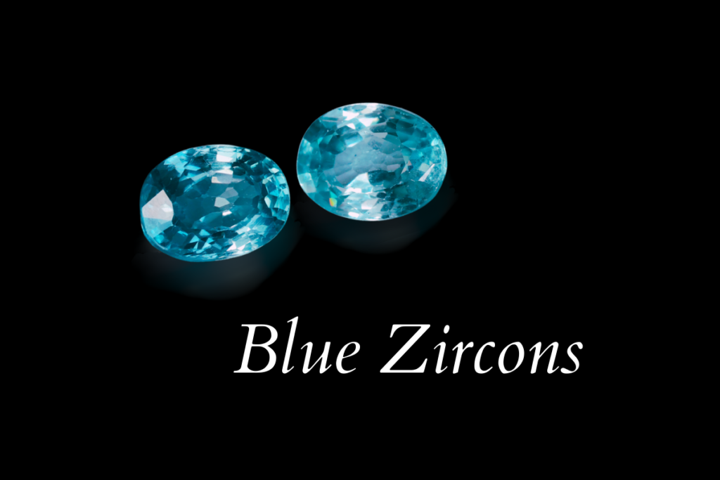 A pair of blue zircons with two slightly different hues on a black background with the text: Blue Zircons