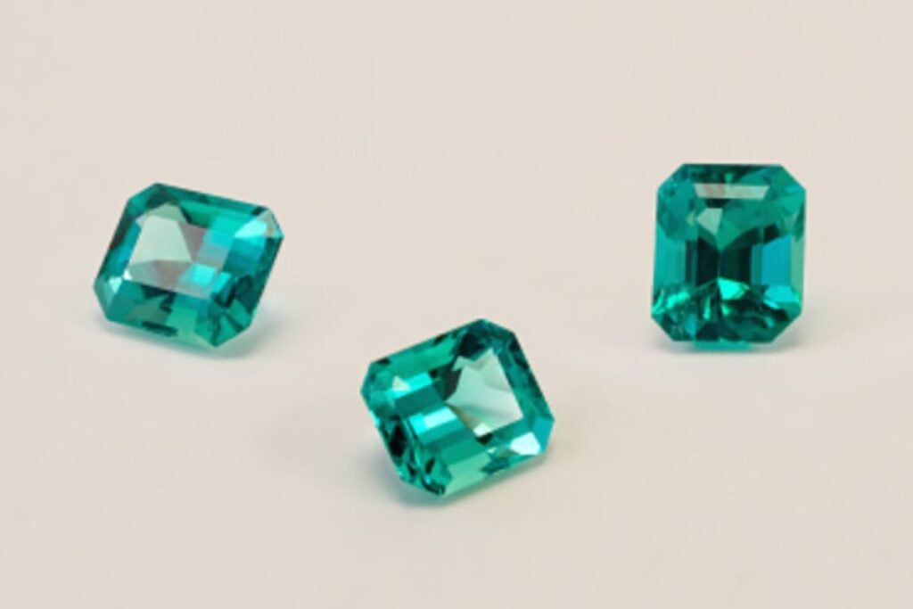 An image showing three colombian emerald on neutral background.