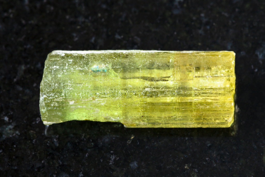 A macro shot of a raw heliodor crystal.